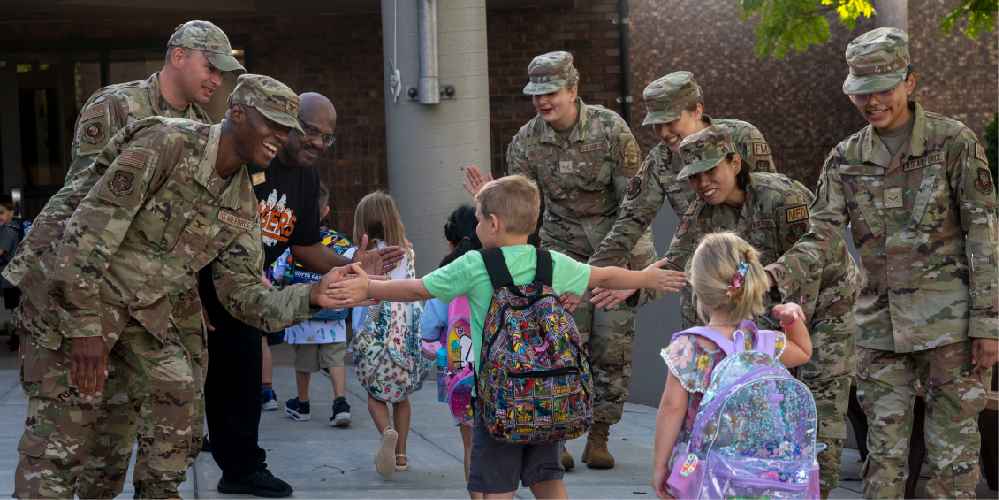 Soldiers standing around children giving them high-fives